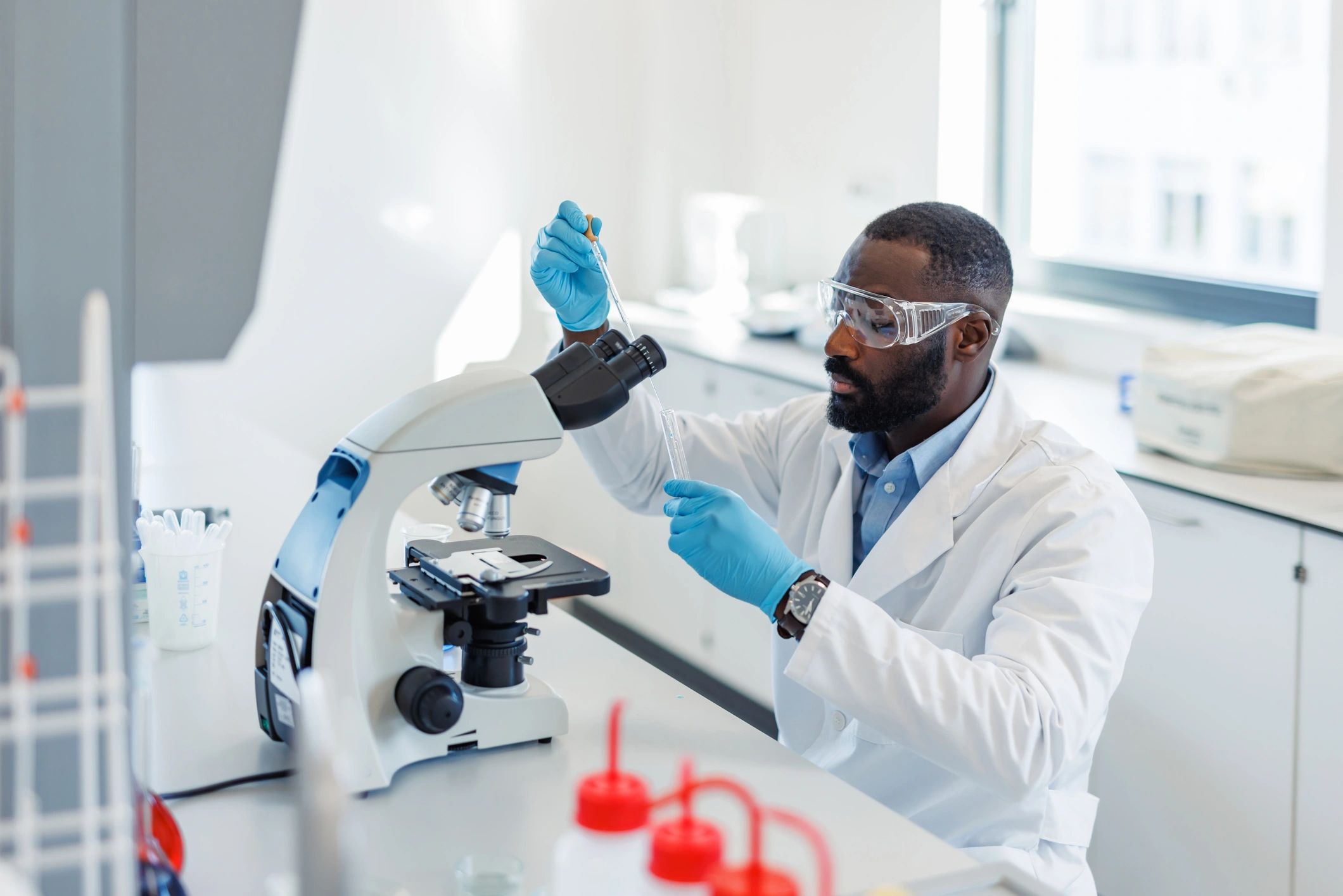 Scientist using a microscope and pipette in a modern laboratory